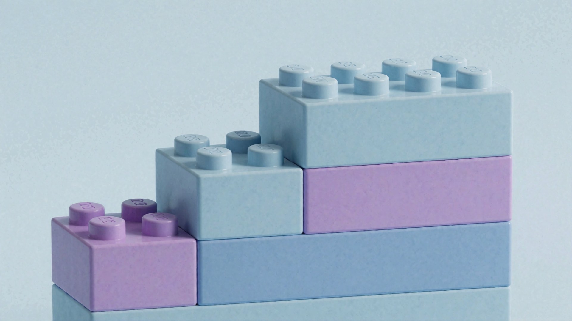 Eine Pyramide aus hellblauen und lila LEGO-Bausteinen vor einem neutralen Hintergrund.